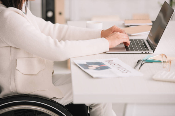 rajattu näkymä vammainen liikenainen kirjoittamalla kannettavan tietokoneen istuessaan työpaikalla
 - Valokuva, kuva