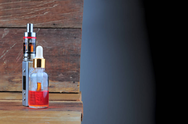 E-Zigarette oder Dampfgerät mit Flüssigkeit auf Holzgrund - Foto, Bild