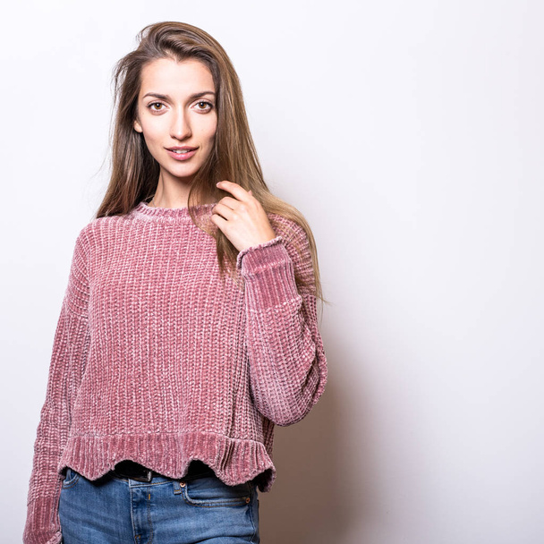 Young model woman in sweater pose in studio. - Foto, afbeelding
