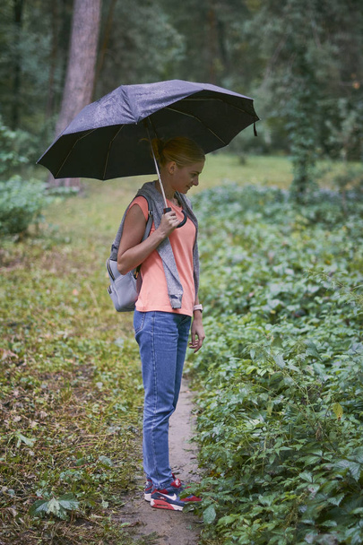 Νεαρή γυναίκα με ομπρέλα στο δάσος - Φωτογραφία, εικόνα