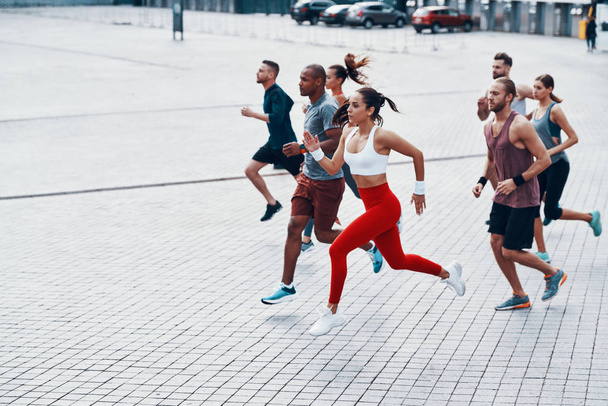 side view of jogging sportive people in street  - Фото, изображение