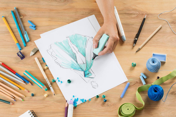 mão com uma escova desenha um esboço na moda em um livro branco ba
 - Foto, Imagem