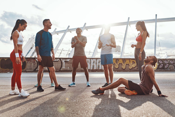 Полная длина молодых людей в спортивной одежде расслабляющий во время занятий на открытом воздухе
                 - Фото, изображение