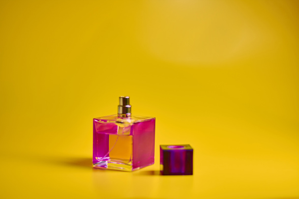 Perfume bottle on yellow background. Minimal style - Foto, imagen