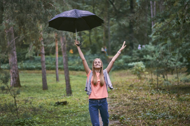 Young woman with umbrella in the forest - Fotografie, Obrázek