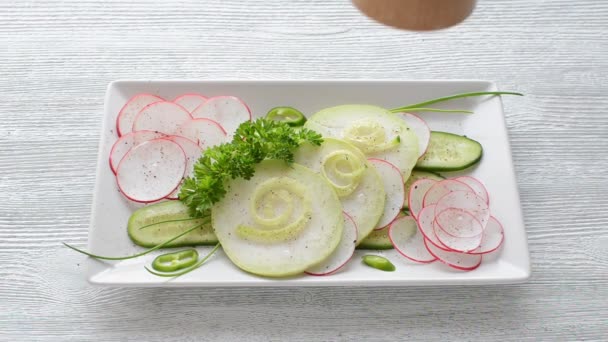 light healthy salad with cucumber, radish, parsley and pepper on wooden table - Footage, Video