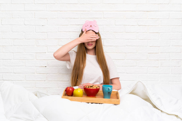 Young woman in dressing gown with breakfast covering eyes by hands - Photo, Image