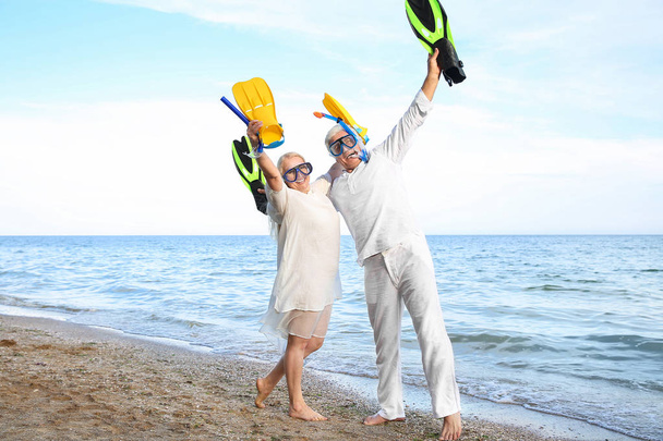 Felice coppia matura con maschere e pagaie snorkeling divertirsi in località di mare
 - Foto, immagini