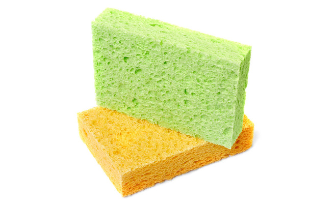 Esponjas coloridas para lavar pratos e outras necessidades domésticas. A esponja verde encontra-se em um amarelo em um ângulo ligeiro. Isolar
 - Foto, Imagem