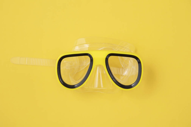 A yellow snorkel and diving mask on a yellow background. overhead lay flat - Фото, зображення