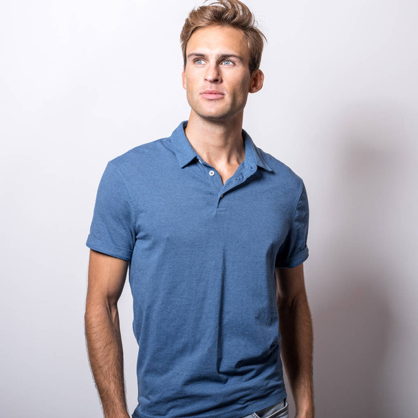 Elegant young handsome man in stylish blue shirt. - 写真・画像