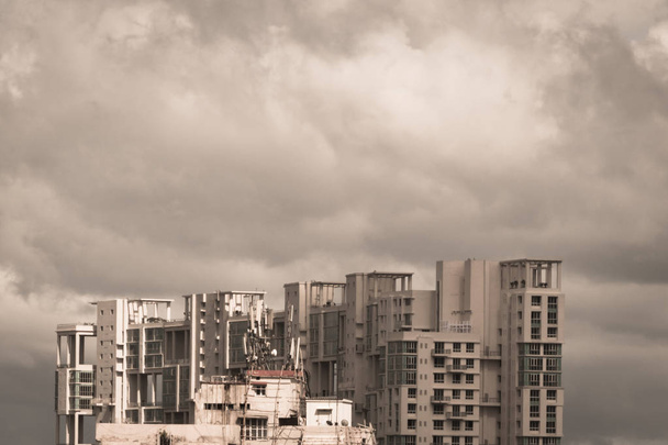 Темные бури Ранние муссоны над современными жилыми небоскребами. Калькутта, Бенгалия, Индия. Город дождливых муссонов вечером. Сильные грозовые облака над высотой. Пейзаж природы
. - Фото, изображение