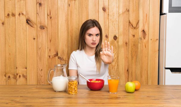 Young blonde woman having breakfast making stop gesture with her hand - Photo, Image