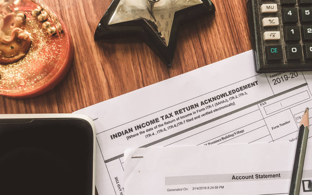 Nahaufnahme des indischen Einkommensteuererklärungsformulars itr-2 liegt auf dem Tisch neben einem Stift, einem Taschenrechner und einem Antragsformular für ein Hypothekendarlehen, das auf dem Schreibtisch liegt. Finanzunternehmenskonzept. - Foto, Bild