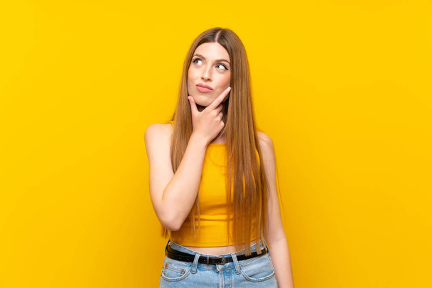 Young woman over isolated yellow background thinking an idea - Foto, Imagem