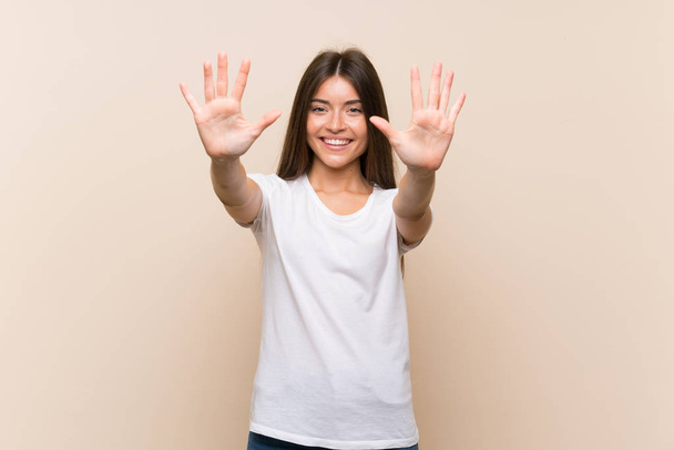Vrij jong meisje over geïsoleerde achtergrond tellen tien met vingers - Foto, afbeelding