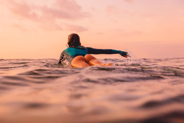 Surf girl con el cuerpo perfecto en la tabla de surf en el océano. Surf en su
 - Foto, imagen