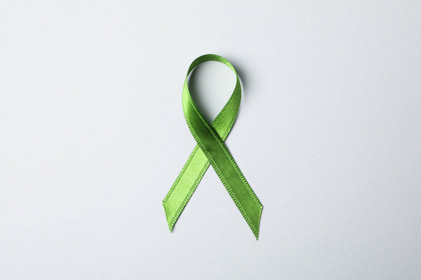 Green awareness ribbon on grey background, space for text - Foto, afbeelding