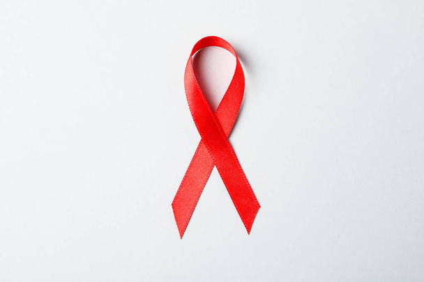 Red awareness ribbon on red background, space for text - Fotó, kép