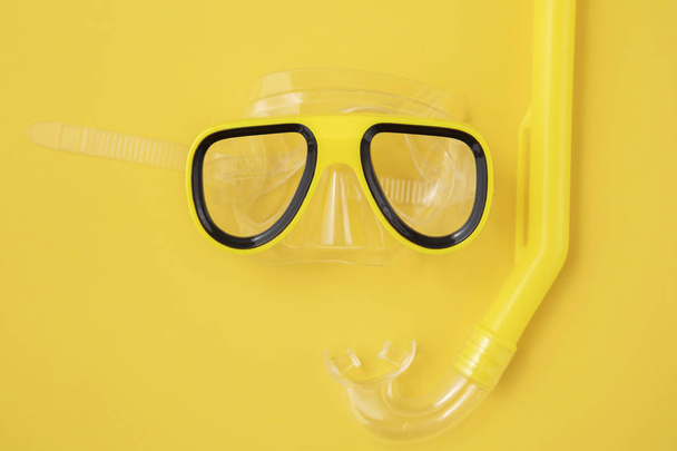 A yellow snorkel and diving mask on a yellow background. overhead lay flat - Foto, afbeelding