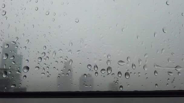 Close up vista de gotas de chuva caindo da janela em um dia nublado com céu cinza
 - Filmagem, Vídeo