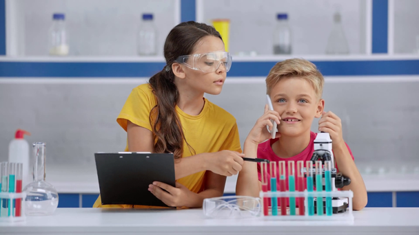 dítě v Googles u chlapce, který mluví v laboratoři  - Záběry, video