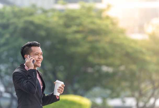 Giovane uomo d'affari malese sul suo Smartphone con una tazza di caffè
. - Foto, immagini