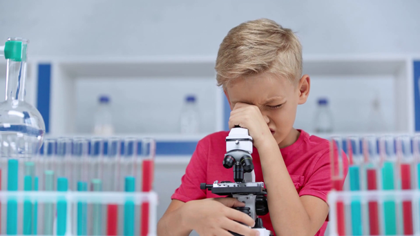 επιλεκτική εστίαση του αγοριού που κοιτάζει μέσα από το μικροσκόπιο  - Πλάνα, βίντεο