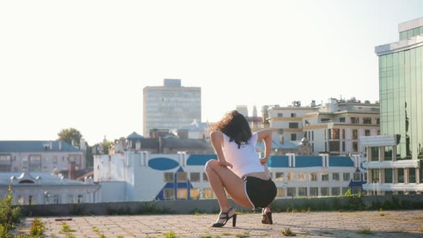 Houkutteleva mulatto nuori nainen seksikäs tanssia korkokengät katolla twerking ja makaa maassa
 - Materiaali, video