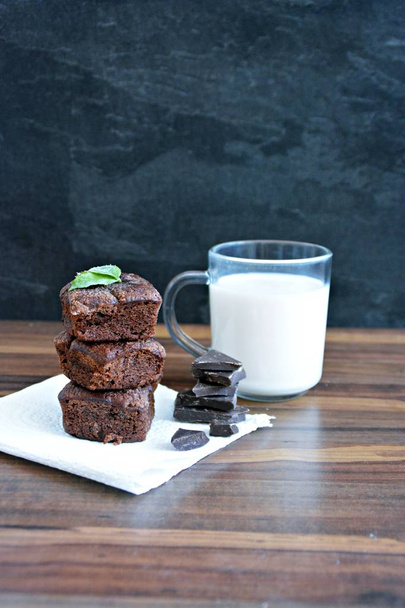 Taze destekli brownies çikolata parçaları ve nane ile ahşap bir masa üzerinde yalan - metin veya diğer unsurlar için yer ile bir masada taze chococlate brownies  - Fotoğraf, Görsel