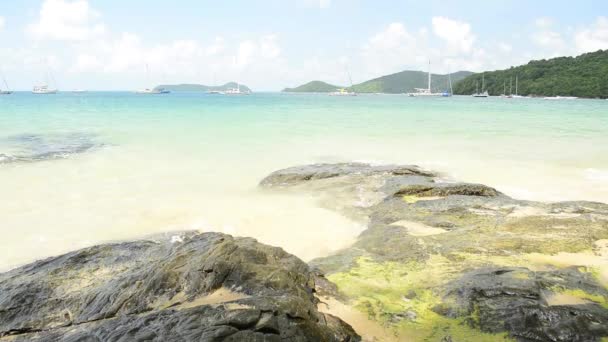Praia rochosa e arenosa bonita com água clara sob céu azul nublado, vista de baixo ângulo na Baía Ao Yon no mar andaman com iates em phuket, Tailândia
. - Filmagem, Vídeo