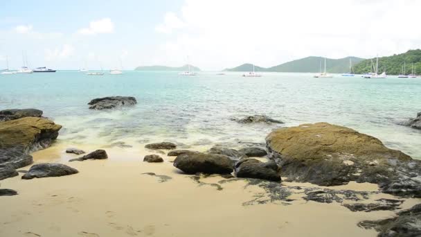 schöner felsiger Sandstrand mit klarem Wasser unter wolkenlosem blauem Himmel, flacher Blick auf die Bucht von ao yon im andamanischen Meer mit Yachten in Phuket, Thailand. - Filmmaterial, Video