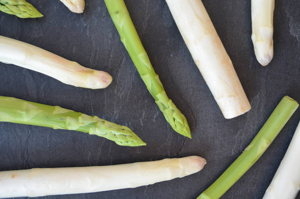 White and green asparagus lie on a dark marble surface  - Photo, Image