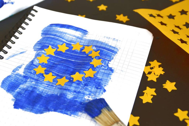 З пензлем і синьою фарбою, а також перфоровані жовті паперові зірки, прапор ЄС був складений на блок-лист-концепція для Європи і єдність в ЄС, щоб відповідати європейським виборах  - Фото, зображення