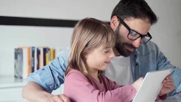 Bello giovane padre con sua figlia che usa il tablet digitale a casa
. - Filmati, video