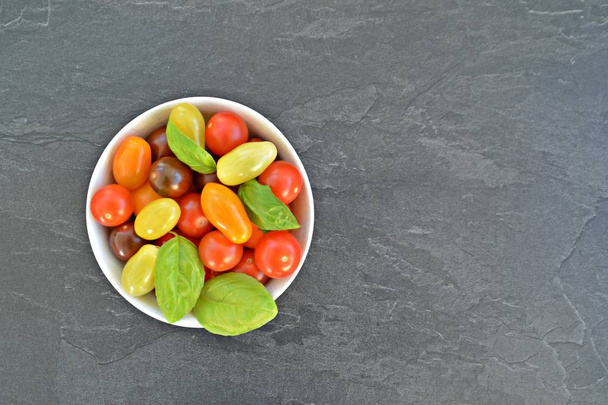 Diferentes tipos de tomates en diferentes colores y albahaca - concepto con tomates frescos y saludables diferentes, con espacio para texto para otros elementos
  - Foto, Imagen