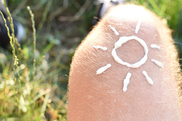 Conceito para proteção contra o sol em dias de praia quente com um pé masculino com uma tornozeleira
  - Foto, Imagem
