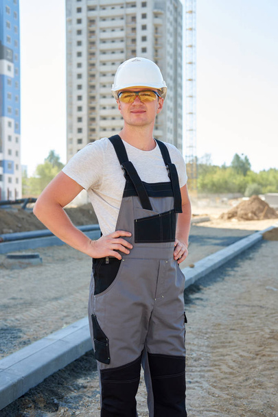 Portrait of young handsome hard worker wearing white protective  - Fotoğraf, Görsel