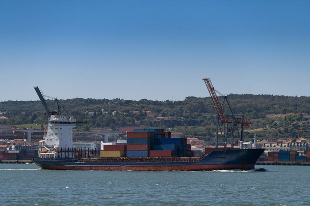 A kikötőt a portugáliai Lisszabonban belépő konténerszállító hajó; Koncepció a közlekedés és a globális gazdaság - Fotó, kép