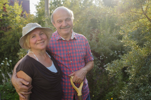 Joyeux couple d'âge mûr se reposant dans le jardin vert d'été
 - Photo, image