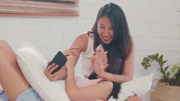 Asian influencer Lesbian lgbtq women couple vlog at home. Young Asia lover girl happy relax record vlog video to social media after wake up lying on bed in bedroom at home in the morning concept. - Footage, Video