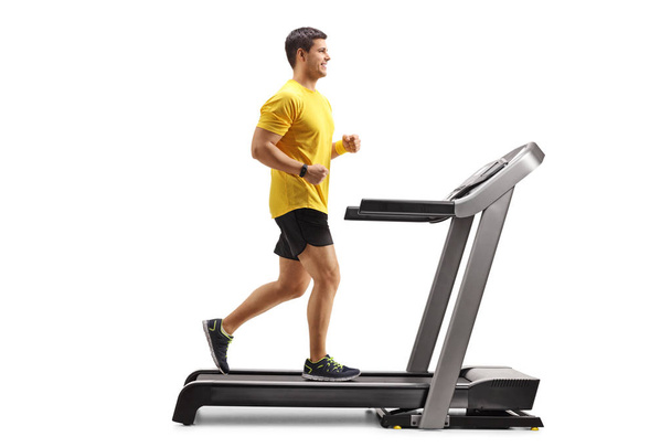 Young man running on a professional treadmill - Фото, изображение