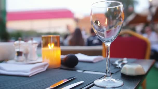 ein leeres Glas steht auf dem Tisch - brennende Kerze - Restaurant im Freien - Filmmaterial, Video
