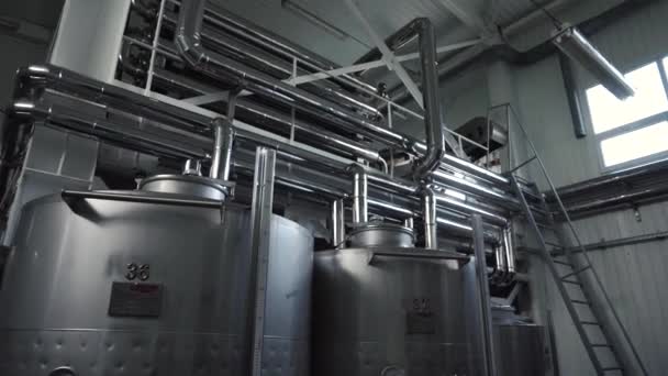 Salón de la fábrica de vino con enormes barricas verticales de acero al vino donde se fermentan las uvas
 - Imágenes, Vídeo