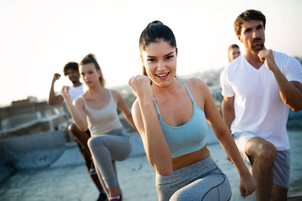 Group of fit healthy friends, people exercising together outdoor - Фото, изображение