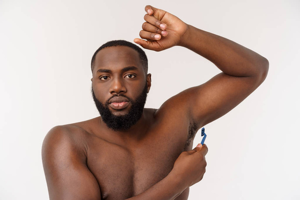 Крупным планом счастливого голого африканца, бреющегося бритвой, изолированного на сером фоне
 - Фото, изображение