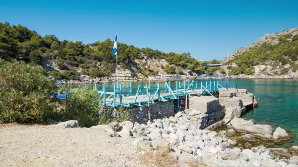 Playa rocosa de Anthony Quinn Bay en la isla de Rodas en Grecia con agua azul clara del mar Mediterráneo durante el tiempo perfecto de verano soleado
 - Imágenes, Vídeo