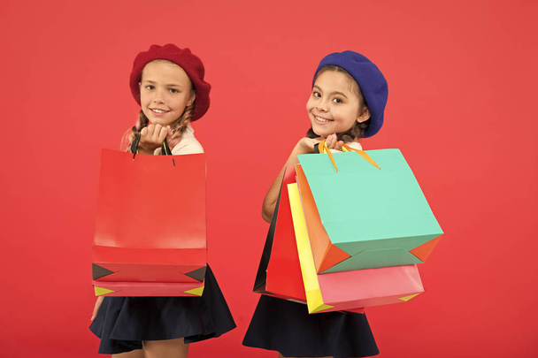Visiting clothing mall. Discount and sale concept. Kids cute girls hold shopping bags. Shopping discount season. Special offer. Great day for shopping. Children enjoy shopping red background - Фото, изображение