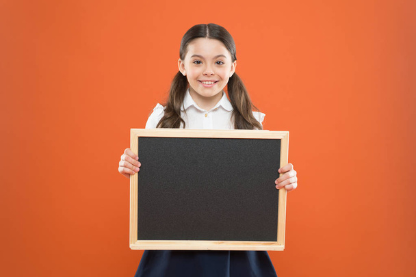 school sales. back to school. happy teachers day. 1 september. small girl demonstrate announcement. happy small school girl with chalkboard. blackboard for copy space. information. write hometask - Фото, изображение