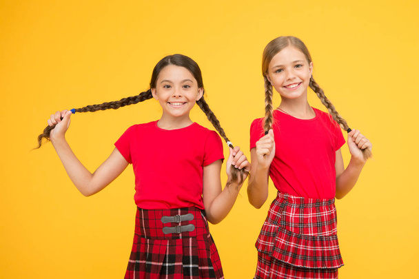 Happy moments. Kids girls sisters best friends in cheerful mood. Beautiful sisters. Children cheerful play with long braided hair. Strong hair. Grow strong and healthy hair. Hair care concept - Foto, Imagem